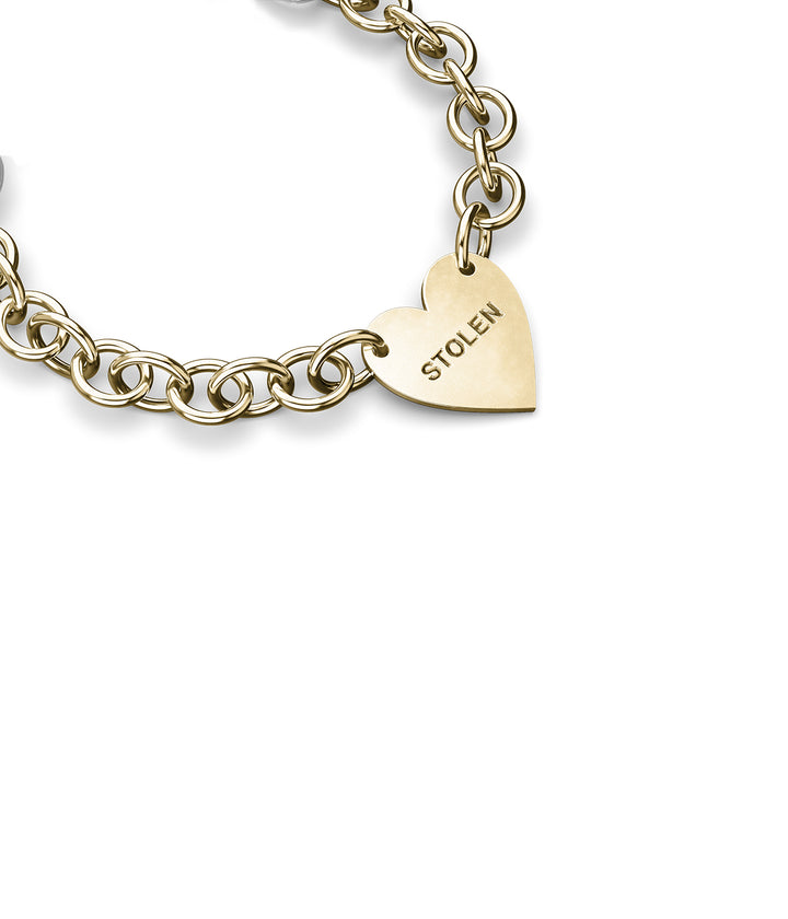 Angle view of Cold Heart Bracelet in solid gold showing links and polished charm.