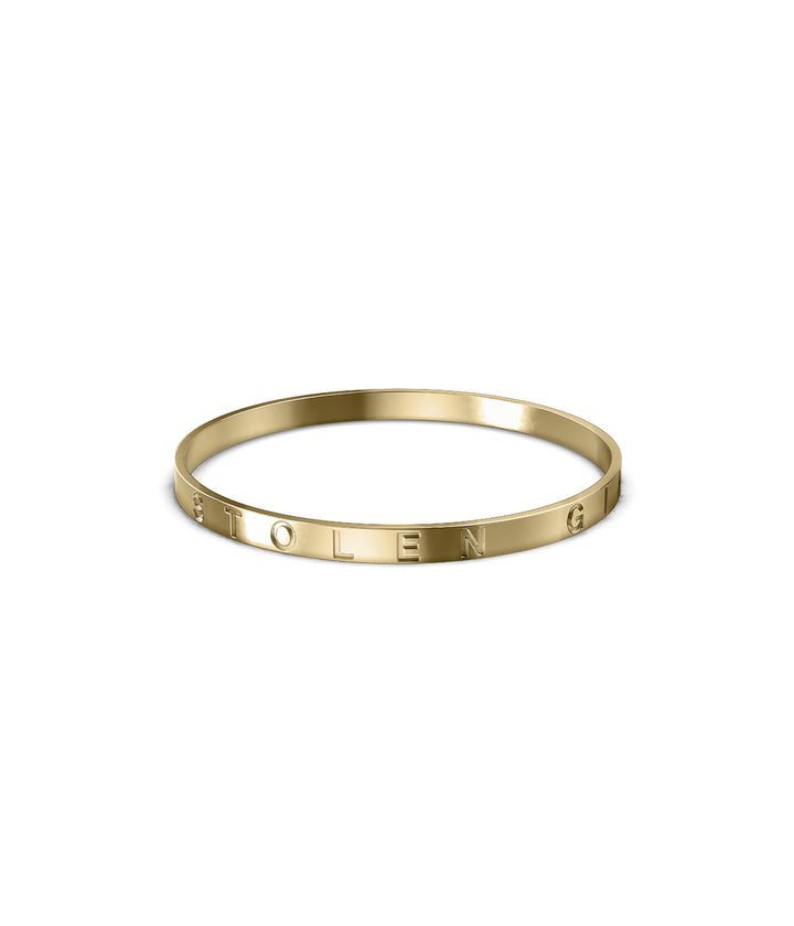 18k gold-plated Stolen Bangle on white background showing polished finish and engraved detail.