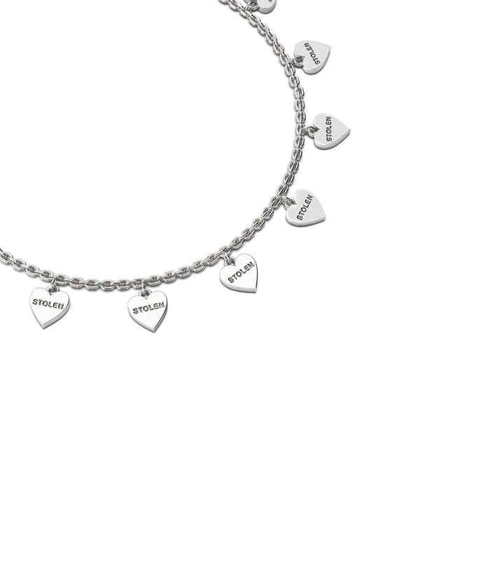 close-up of silver Stolen Heart bracelet with charms. Best Seller 