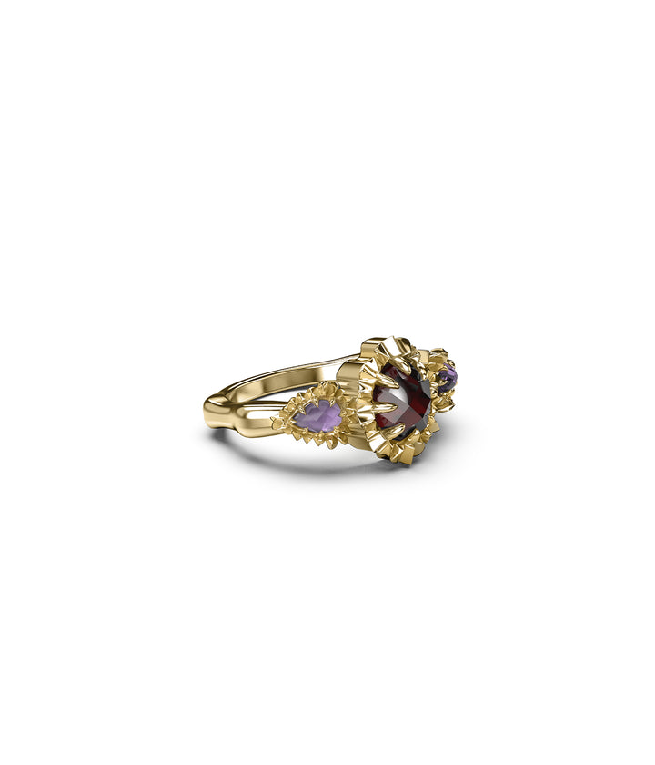 Three-quarter angled view of gold triple gemstone ring on white background