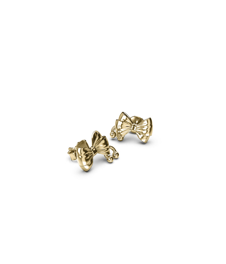 Close-up of gold earrings showing dimensional bow design and subtle piercing.