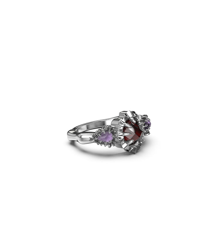 Angled view of silver triple gemstone ring showing garnet and amethysts