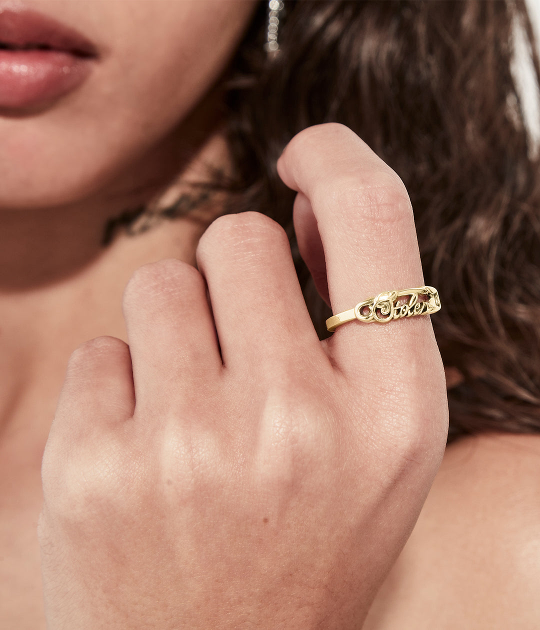 Gold Scripted Satefy Pin Ring worn on female hand, styled minimally to show proportion.
