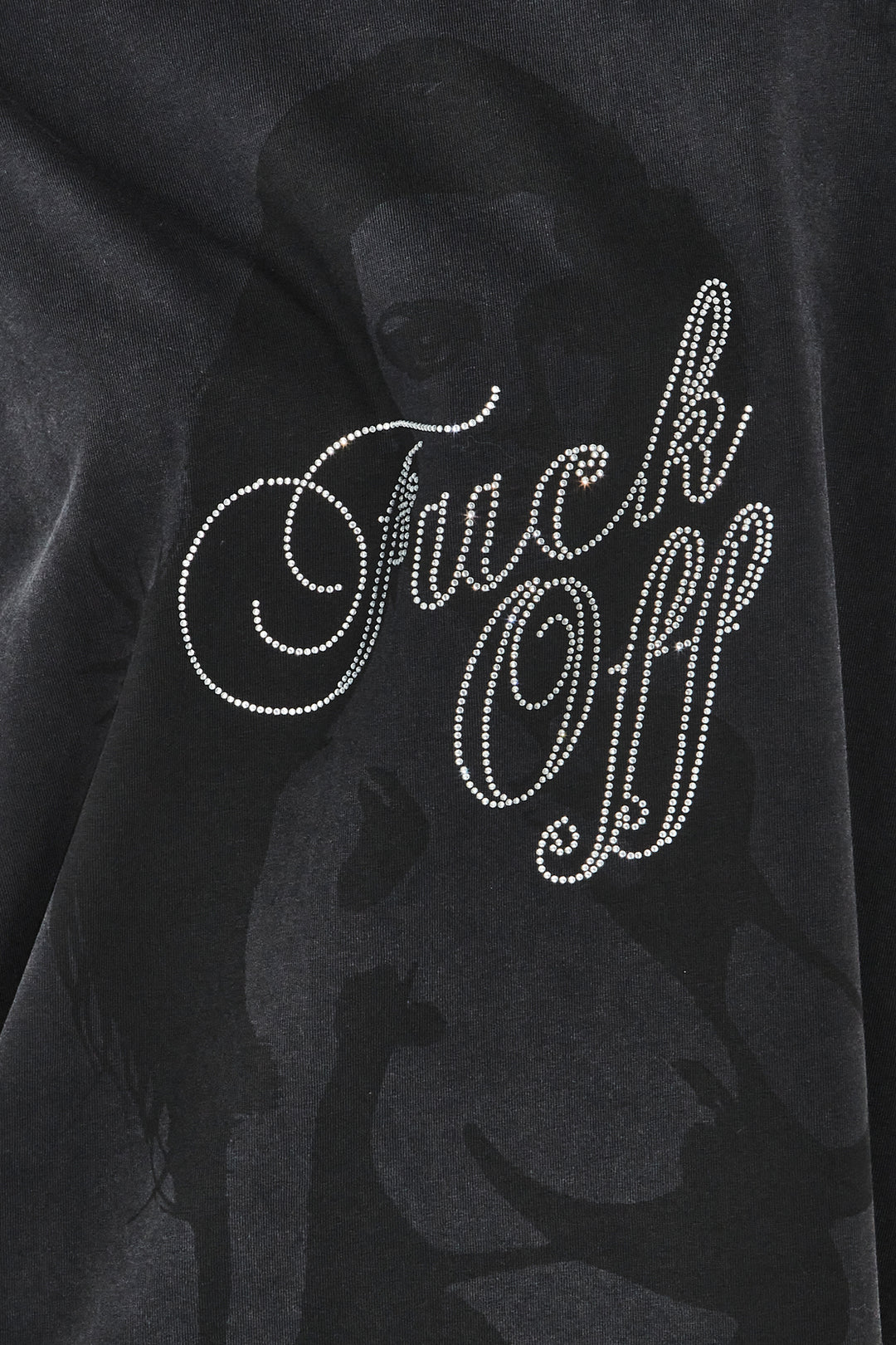 Black sweatshirt with 'F**k Off' text in rhinestones on a dark background
