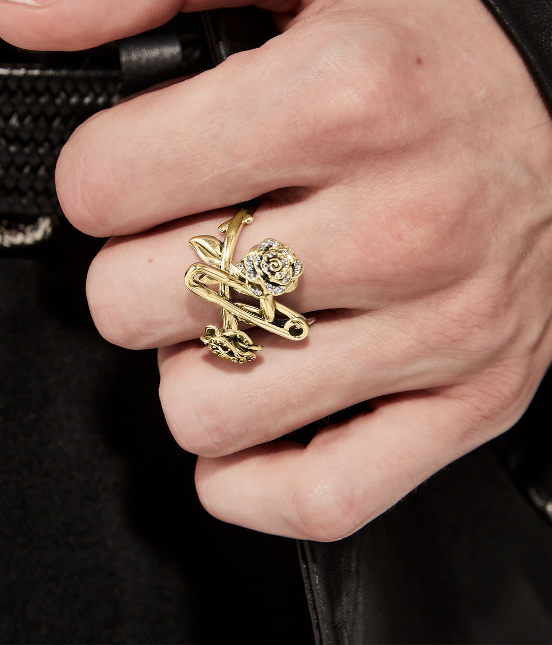 Close up, on model view of gold plated topaz encrusted rose and pin ring for scale and detail.