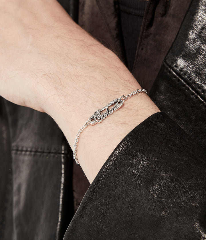 Scripted Pin Bracelet worn by male model on dark background showing sizing and styling in sterling silver 