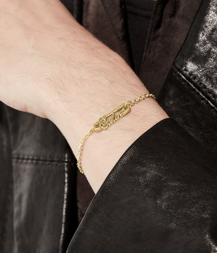 Bracelet styled on male wrist in low light, worn alone to show chain length.