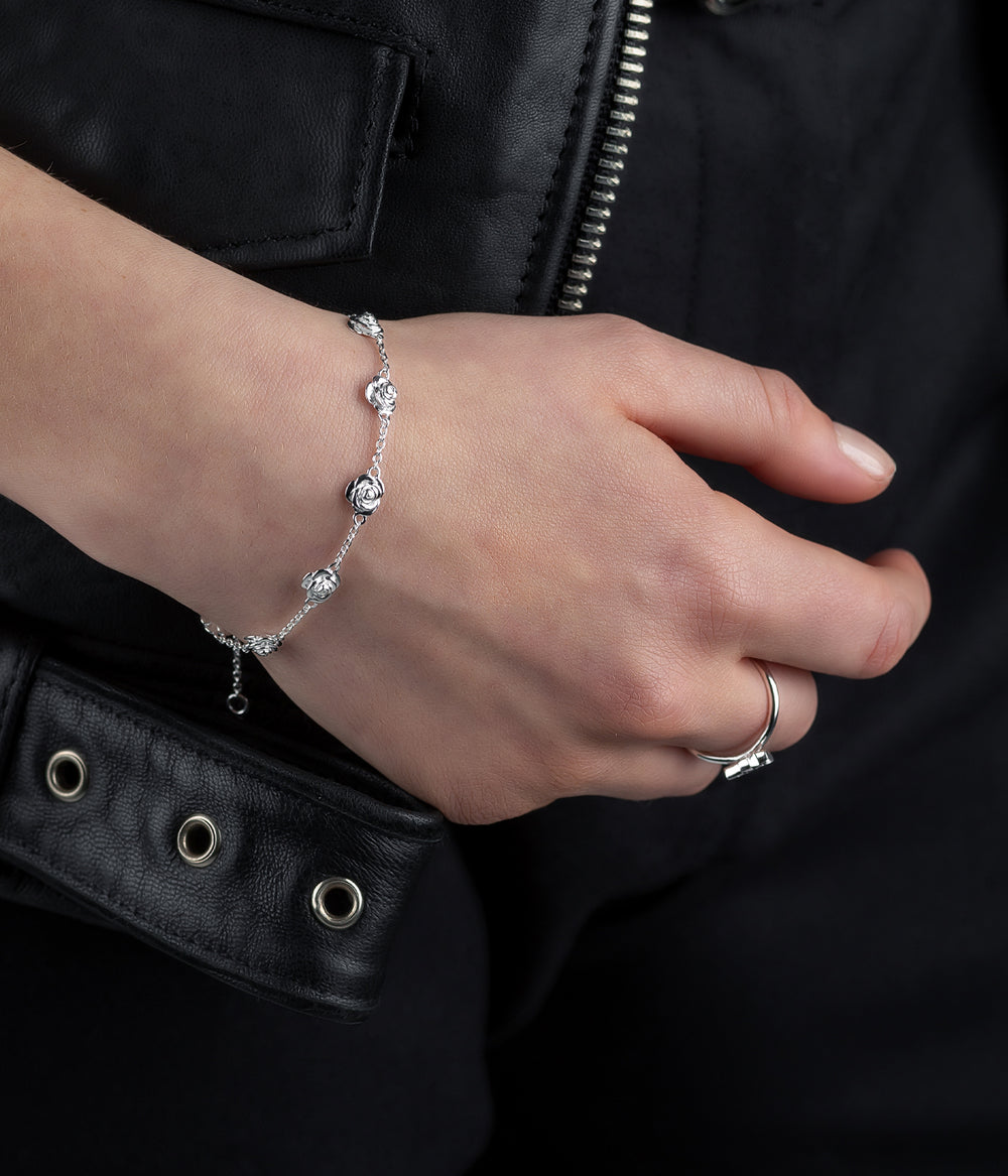 Sterling silver Rose Bud Bracelet styled on female wrist, showing scale and soft floral detailing in natural light.