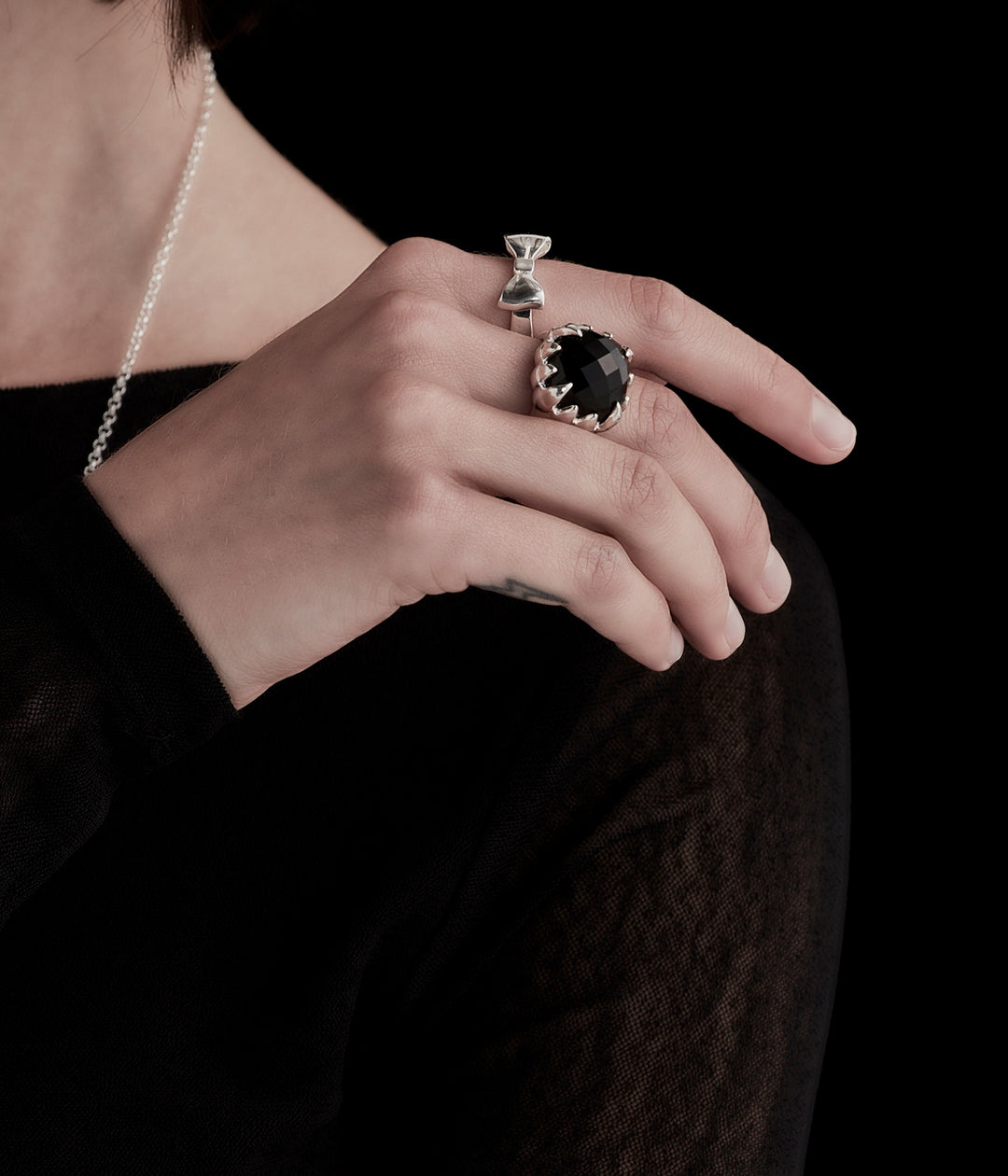 On-model close-up of the sterling silver Bow Ring on female hand, styled minimally  to emphasise daily wear 