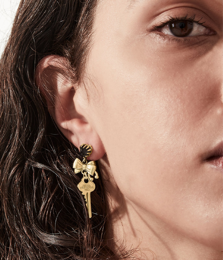 Profile of key earring showing engraved logo and charm detail.