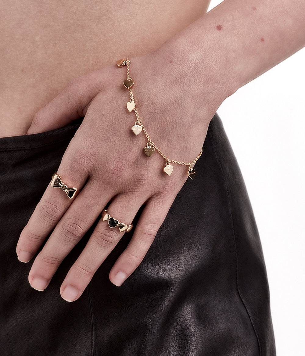 Gold bracelet worn on wrist, styled to show charm movement and warmth.