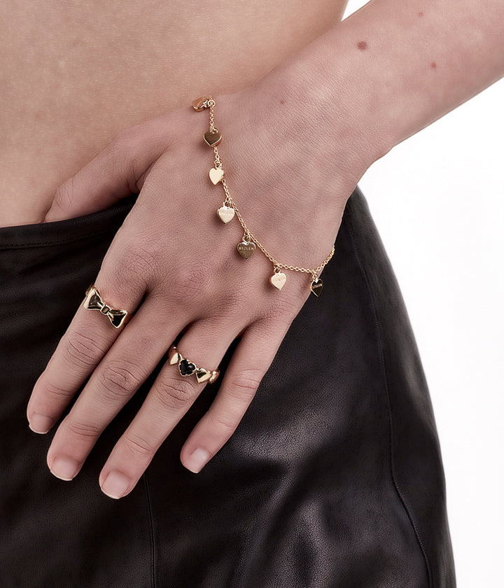 Gold bracelet worn on wrist, styled to show charm movement and warmth.