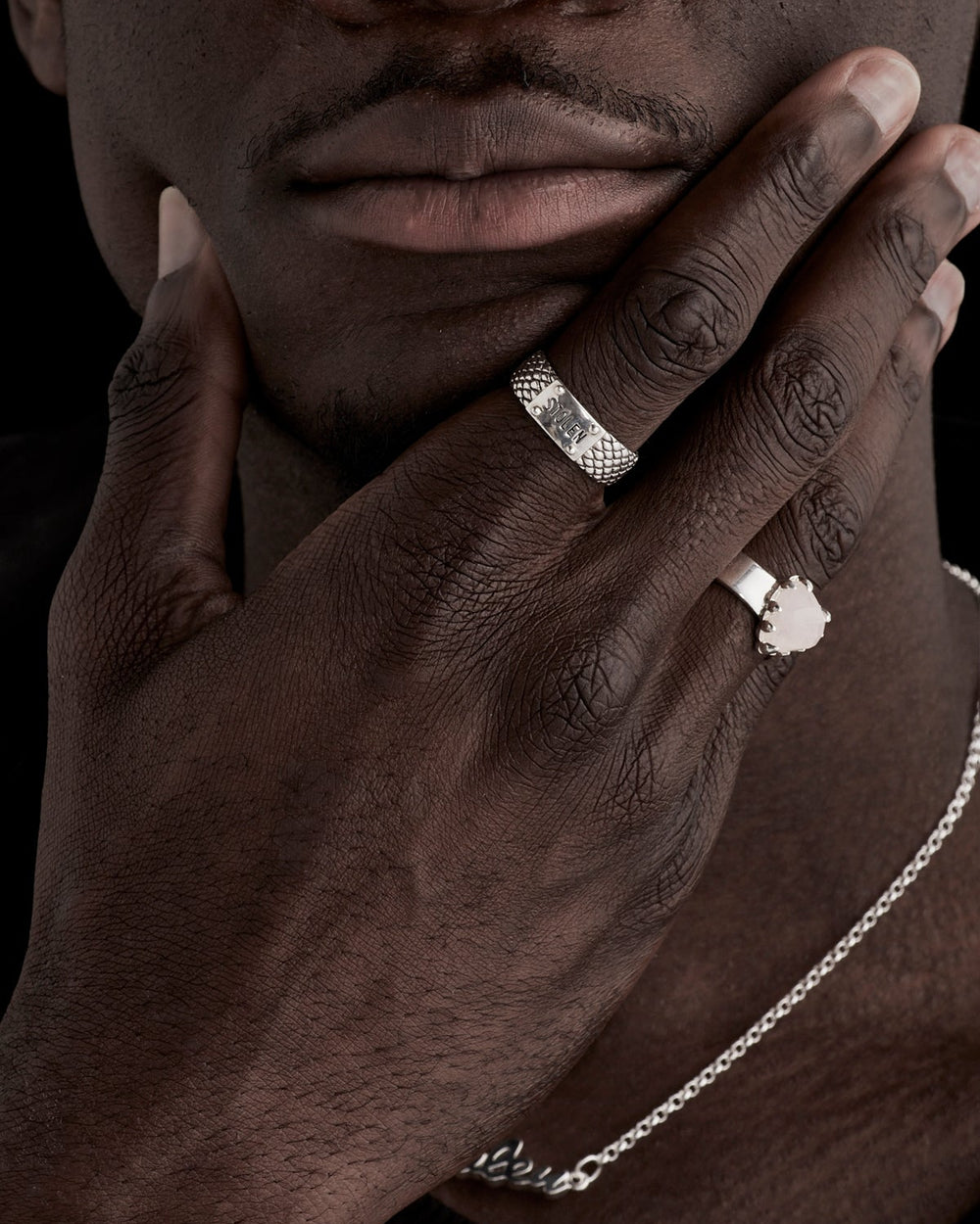 Narrow Snake Band Ring worn by male model, layered with Love Claw ring, showing contrast between textured and smooth silver bands in close-up hand styling